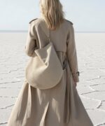 Ana Suede Bag in beige shown over the model's shoulder. Showing wide strap and soft oversized silhouette